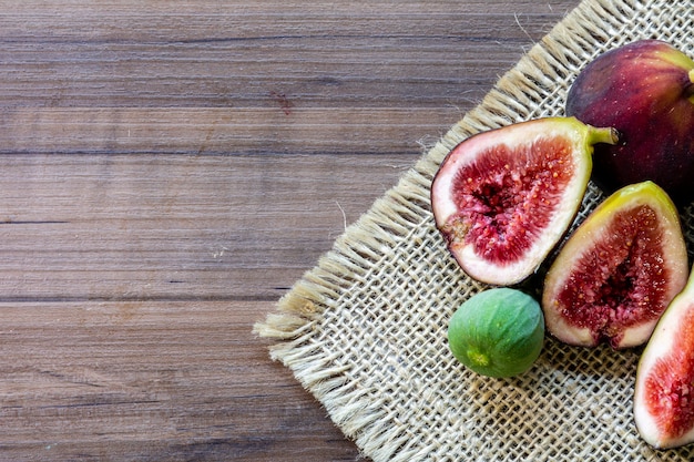 Fichi, foglie verdi su fondo di legno rustico