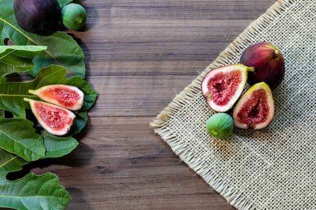 Fichi, foglie verdi su superficie di legno rustica