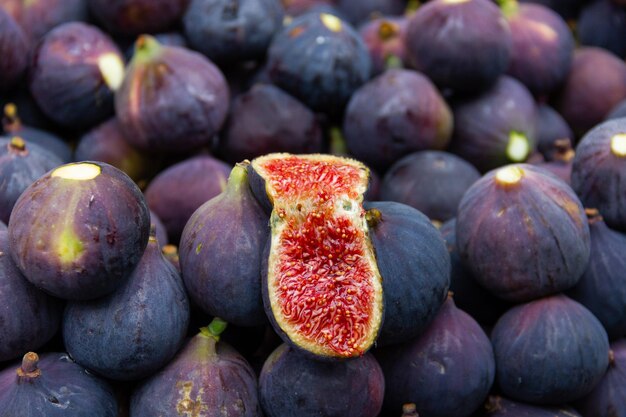 Fichi freschi aperti a metà sopra quelli viola pieni sulla bancarella del cibo di strada. Mercato della frutta a Istanbul