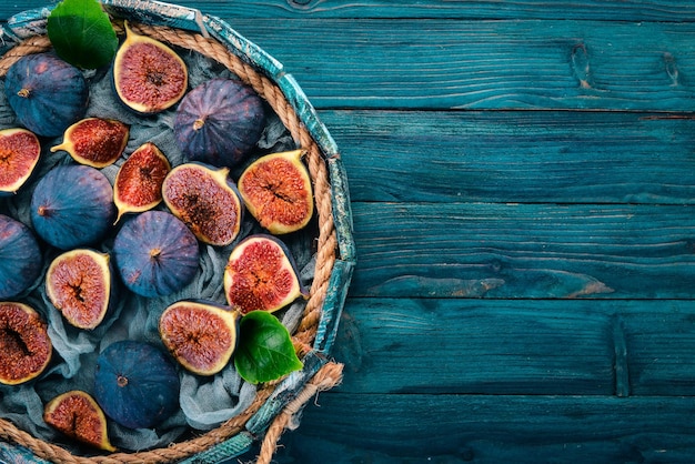 Fichi freschi in una scatola di legno su sfondo blu Spazio libero per il testo Vista dall'alto