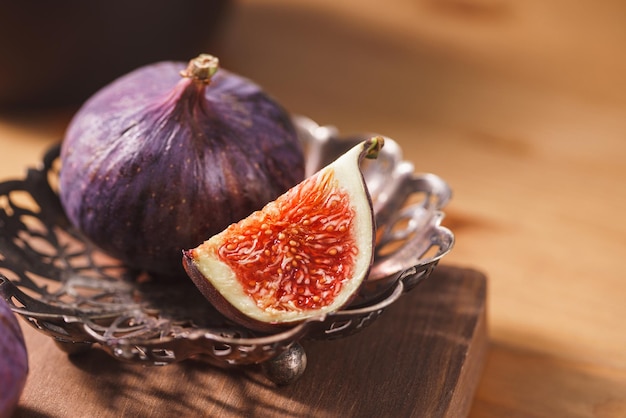 Fichi freschi maturi in vaso su fondo in legno Raccolta di frutta autunnale