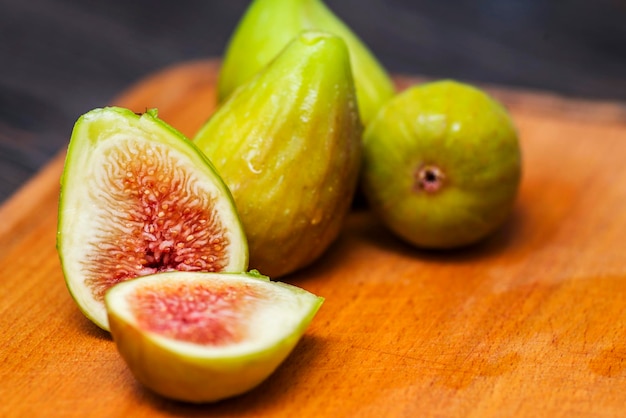 Fichi freschi maturi su un tagliere da cucina su un tavolo di legno rustico Fichi gustosi maturi