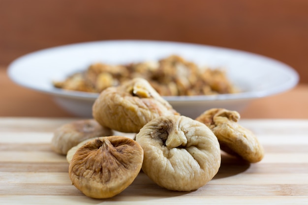 Fico secco e uva sul piatto di legno. Avvicinamento. Preparato per tritare