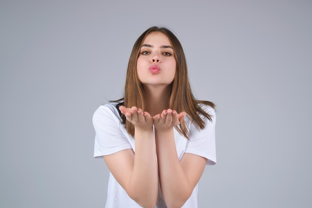 Fidanzata che bacia qualcuno ritratto di una bella ragazza che ti bacia isolato sullo sfondo dello studio carino