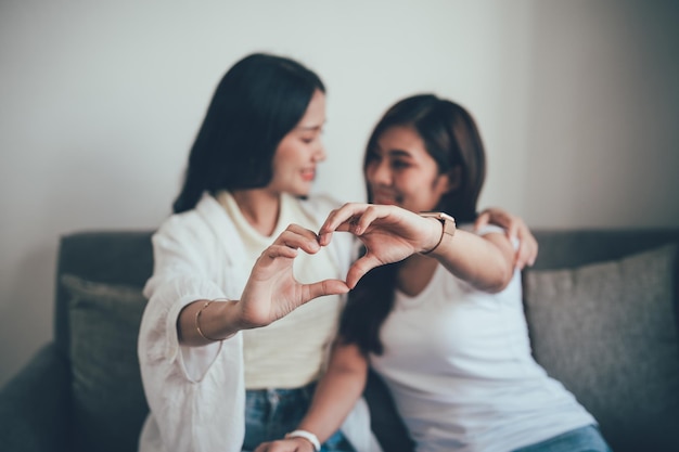 Fidanzate di stile di vita lesbico che fanno il simbolo a forma di cuore con il tono vintage del gesto della mano