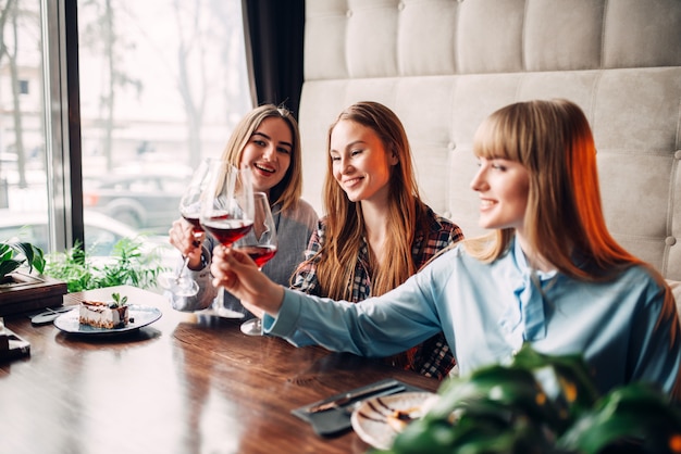 Fidanzate tintinnano bicchieri con vino rosso