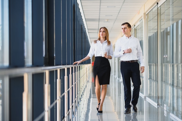 Fiduciosi partner commerciali scendendo in edificio per uffici e discutendo di lavoro