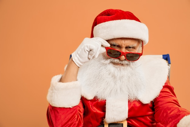 Fiducioso Babbo Natale che guarda l'obbiettivo attraverso gli occhiali da sole