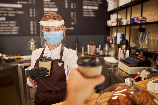 Fiducioso barista protetto al lavoro durante la quarantena