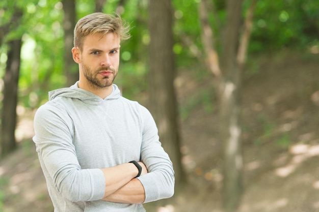 Fiducioso e fisicamente in forma. L'atleta sicuro tiene le braccia incrociate all'aperto. Sguardo sicuro dell'uomo muscoloso. Tipo atletico. Fiducioso e sano. Allenamento sportivo e allenamento. Renditi orgoglioso.