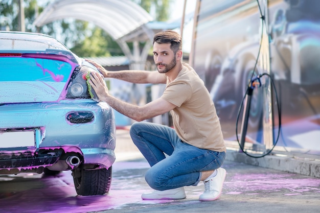 Fiducioso giovane con asciugamano vicino all'auto