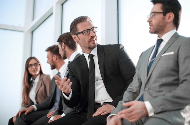 Fiducioso giovane manager qualificato seduto con i suoi colleghi a un seminario