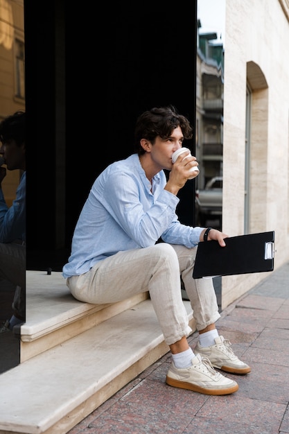 Fiducioso giovane uomo casual che beve caffè