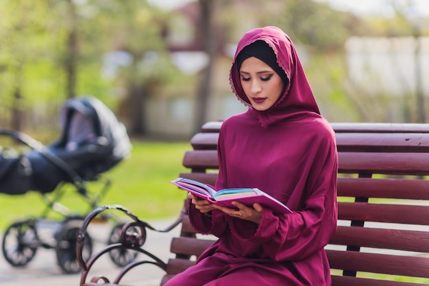 Fiducioso uomo d'affari arabo sorridente e passeggiate di dubai arab business vumen hijab è nelle strade contro i grattacieli di dubai la donna è vestita con un abaya nero