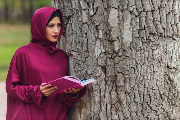 Fiducioso uomo d'affari arabo sorridente e passeggiate di dubai arab business vumen hijab è nelle strade contro i grattacieli di dubai la donna è vestita con un abaya nero