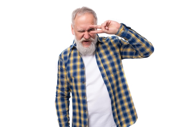 Fiducioso uomo dai capelli grigi maturo con la barba in una camicia su sfondo bianco con spazio per la copia