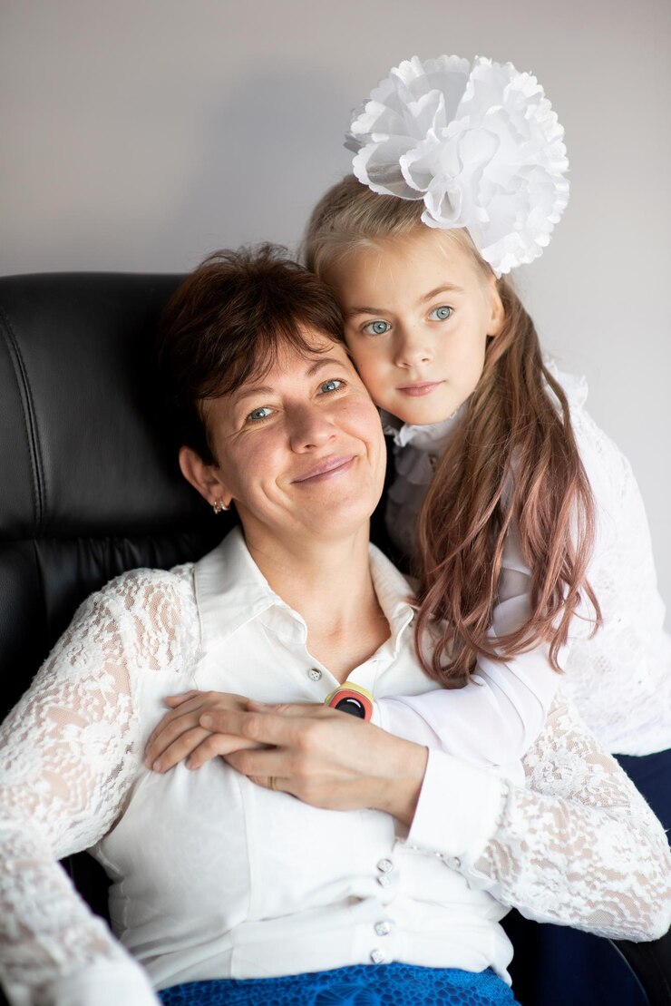 Foto figlia che abbraccia la madre seduta su una sedia contro il muro