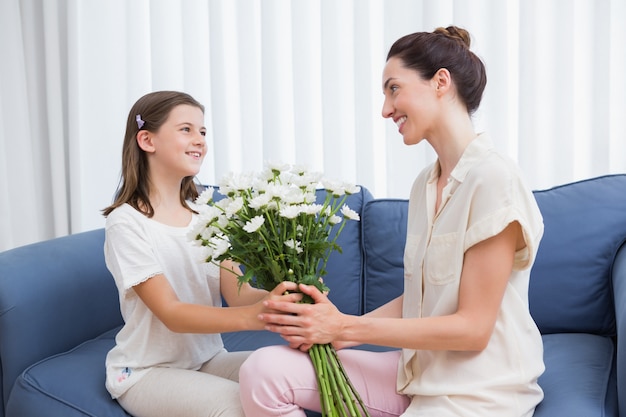 Figlia che dà al mazzo bianco madre