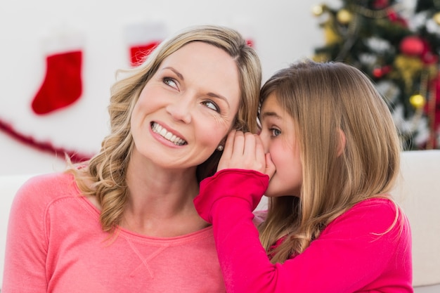 Figlia che dice a sua madre un segreto di Natale