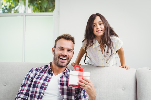 Figlia e padre felici con un contenitore di regalo