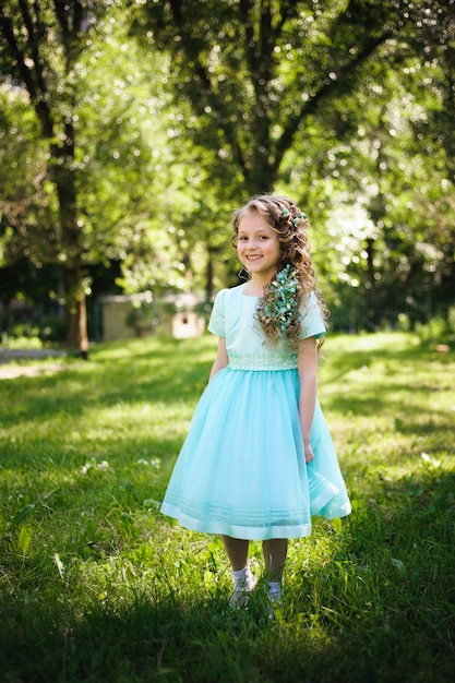 Figlia felice che sorride alla macchina fotografica nel parco di estate