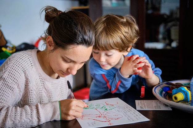 Figlio che guarda una donna che scrive su carta