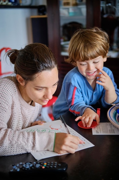 Figlio che guarda una donna che scrive su carta