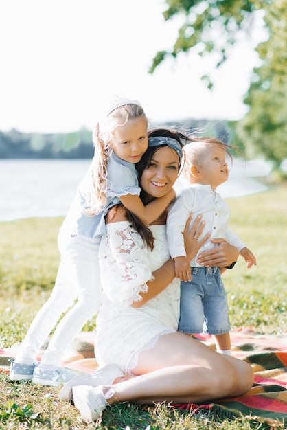 Figlio e figlia abbracciano la madre Picnic estivo nella natura