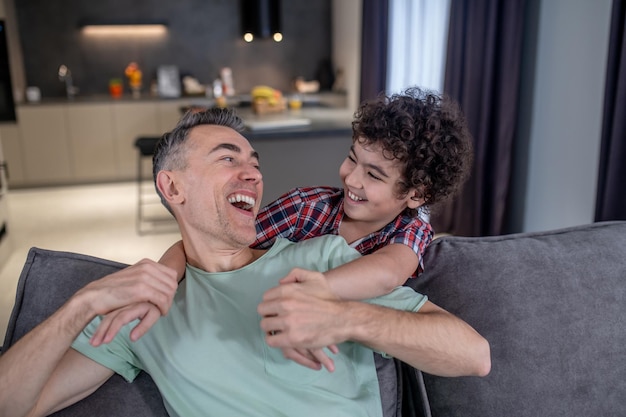 Figlio e padre che ridono guardandosi