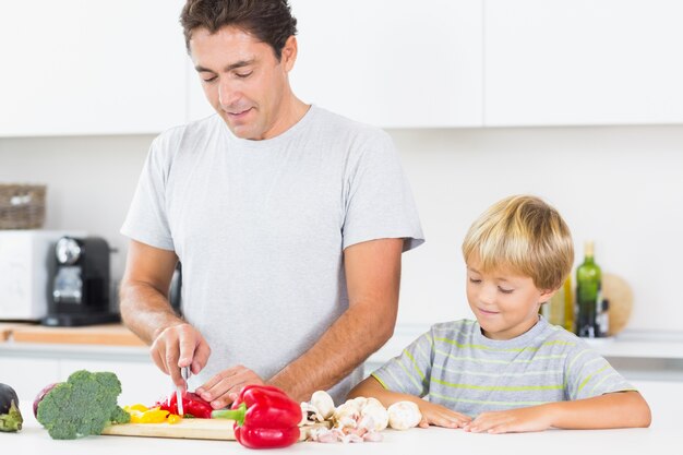 Figlio guardando padre a preparare verdure