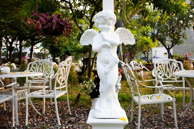 Figura di angelo in stile europeo e giardinaggio esterno design decorazione mobili nel parco giardino presso l'hotel resort all'aperto nella campagna rurale Khlong Wan Village a Prachuap Khiri Khan Thailandia