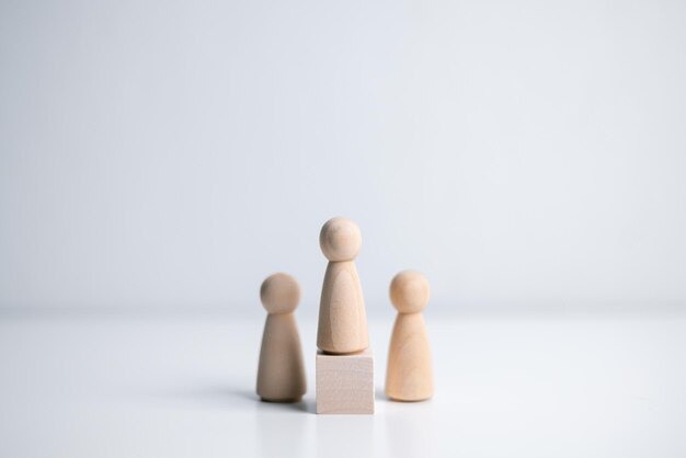 Figura in legno in piedi sulla scatola per mostrare influenza e empowerment concetto di leadership aziendale per il leader squadra vincitore di una competizione di successo e leader con influenza