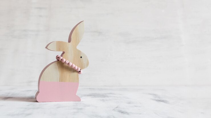 Foto figura rosa del coniglio di pasqua in legno su sfondo bianco vintage cartolina di pasqua copia spazio