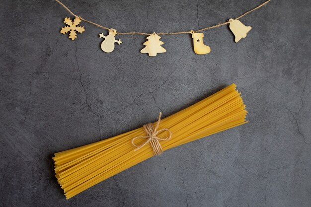 Figure di legno di Natale su una corda e pasta secca su uno sfondo scuro Vacanze di concetto Christmas