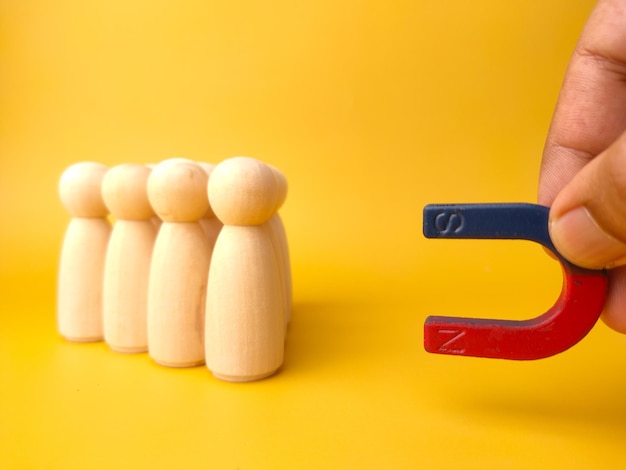 Figure in legno di persone e un magnete Concetto di gestione del team Risorse umane Promuovere la scelta