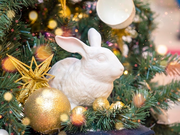 Figurina di un coniglio in ceramica con palloncini sotto l'albero Un simbolo del prossimo anno 2023