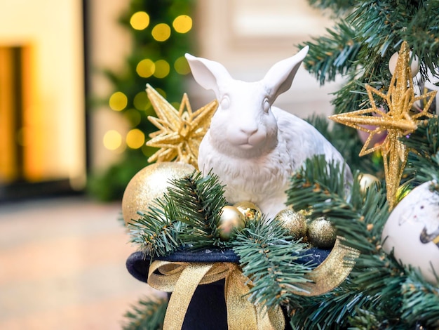 Figurina di un coniglio in ceramica con palloncini sotto l'albero Un simbolo del prossimo anno 2023