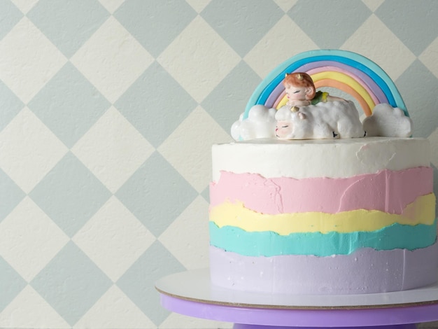 Figurina fatta di mastice a forma di una bellissima bambina su una pecora nuvole e un arcobaleno per la torta di compleanno