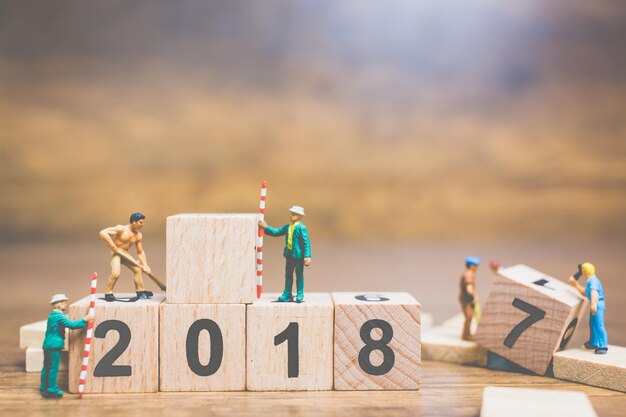 Figurine che lavorano su blocchi di giocattoli con numeri sul tavolo
