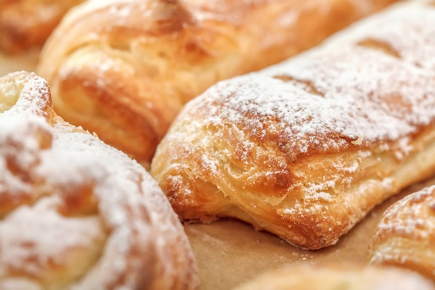 Fila dei panini di recente dolci con la polvere dello zucchero, fuoco selettivo