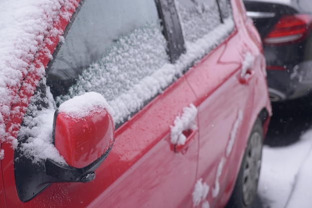 Fila di automobili coperte di neve