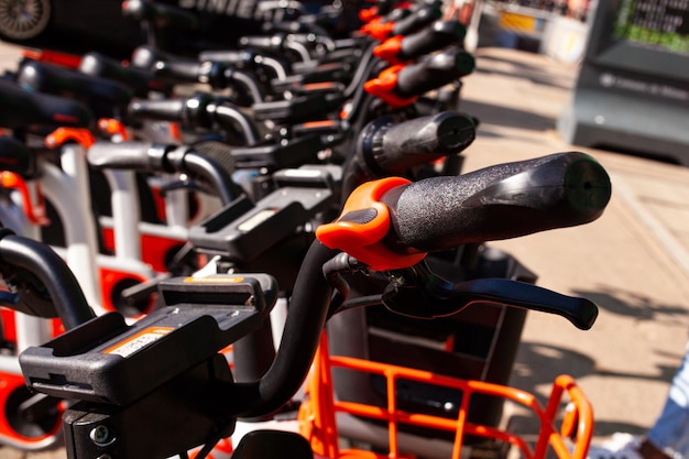 Fila di biciclette parcheggiate in città in affitto sul marciapiede a Milano