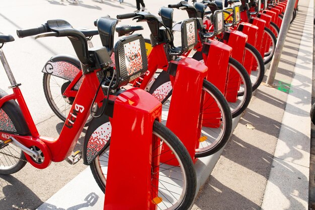 Fila di biciclette rosse in un portabiciclette, disponibili per il noleggio per le strade di Barcellona.