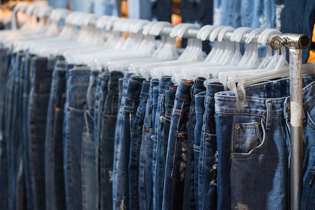 Fila di jeans e pantaloni sui ganci in vendita.