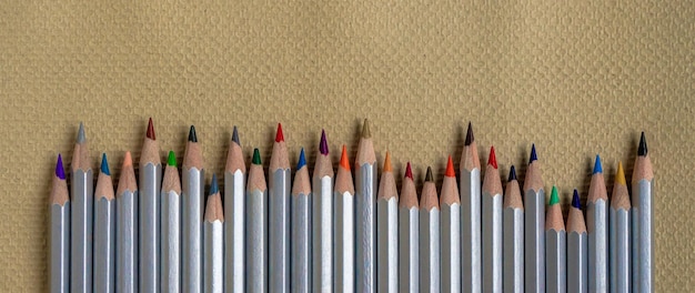 Fila di matite colorate su carta goffrata con copia spazio
