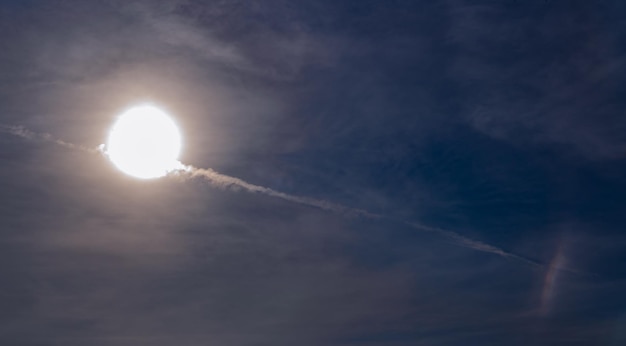 Fila di tracce di aeroplani nel cielo attraverso il sole