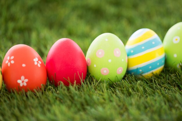 fila di uova di Pasqua colorate sull'erba artificiale