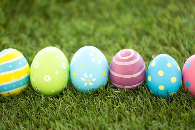 fila di uova di Pasqua colorate sull'erba artificiale