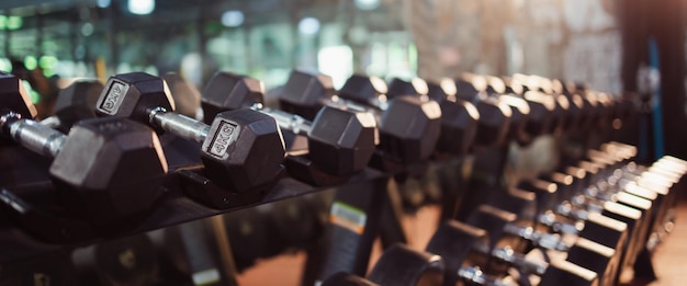 File di manubri in palestra sport e concetto di assistenza sanitaria