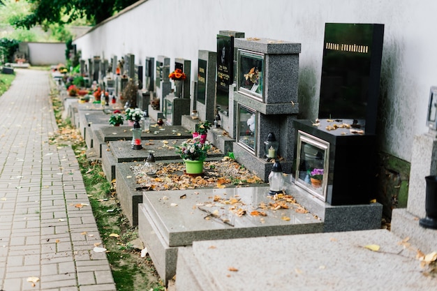 File di vecchie tombe abbandonate in un cimitero cattolico. Le lapidi traballanti.